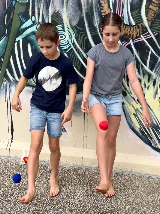 Kids playing hacky sack footbag outdoors