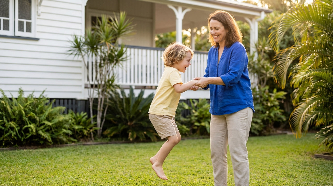 Woman and child playing in a garden in front of a house